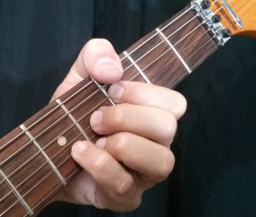 pulgar pisando la sexta cuerda G13b9